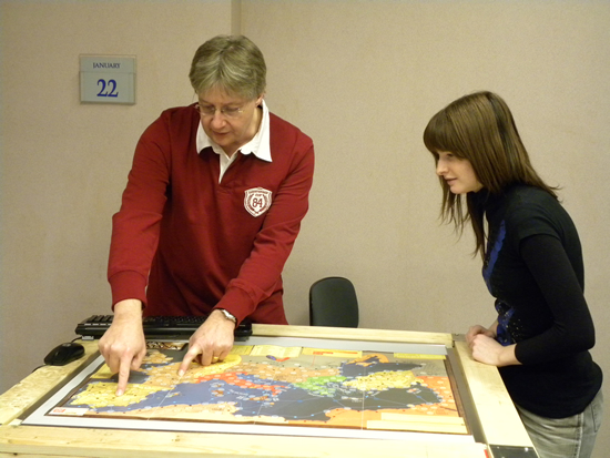 Dr. Neil Randall demonstrates a digital table adaptation of a board game to a student at the CML.